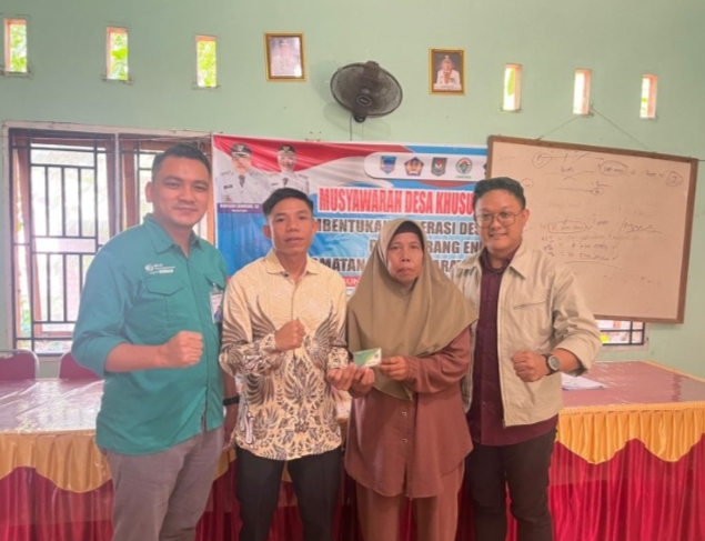 Kepala Desa Karang Endah dan Kepala BPJSTK membagikan kartu BPJS Ketenagakerjaan kepada masyarakat.